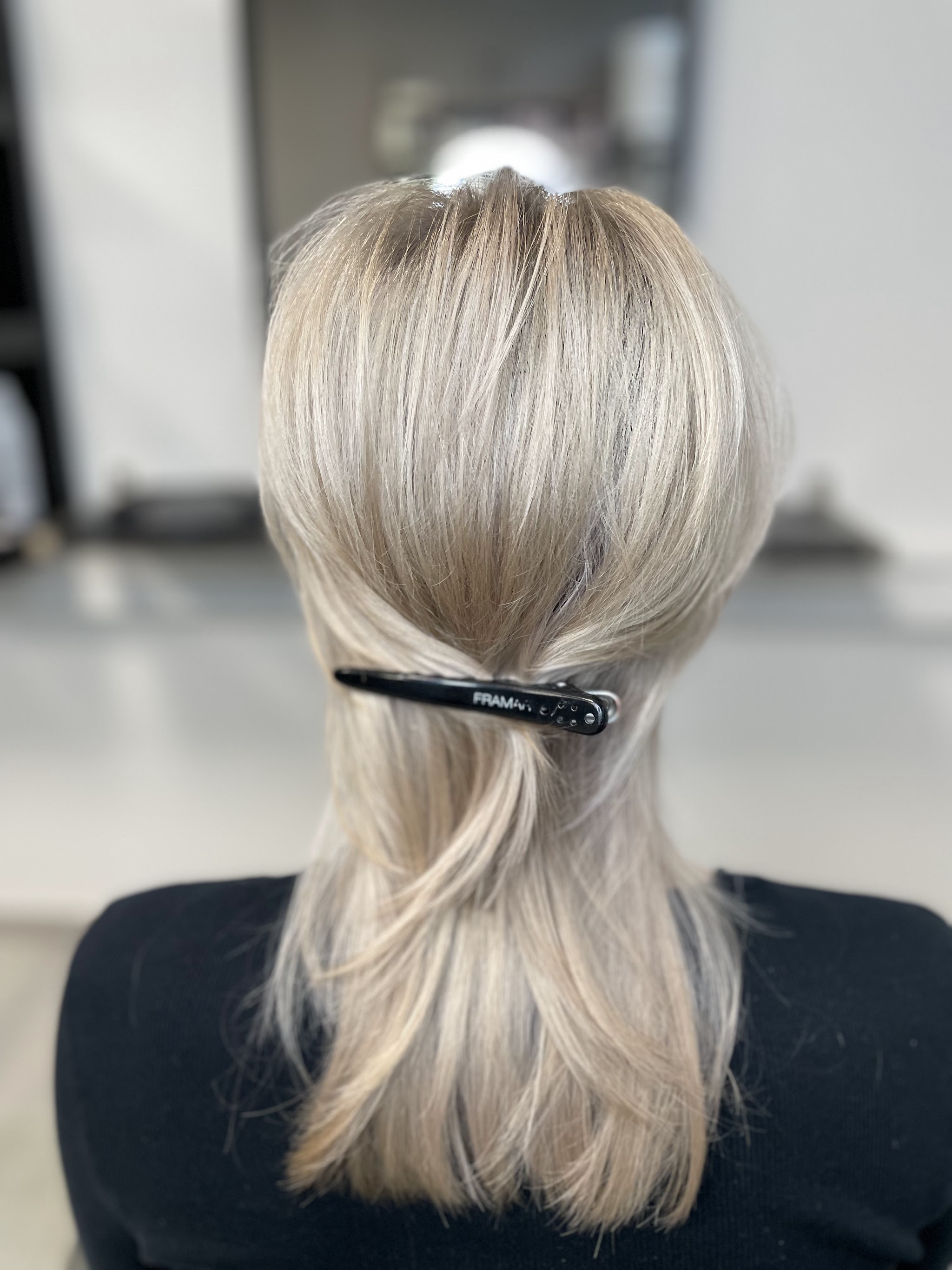 Kort lichtblond haar, half opgestoken met een klem
